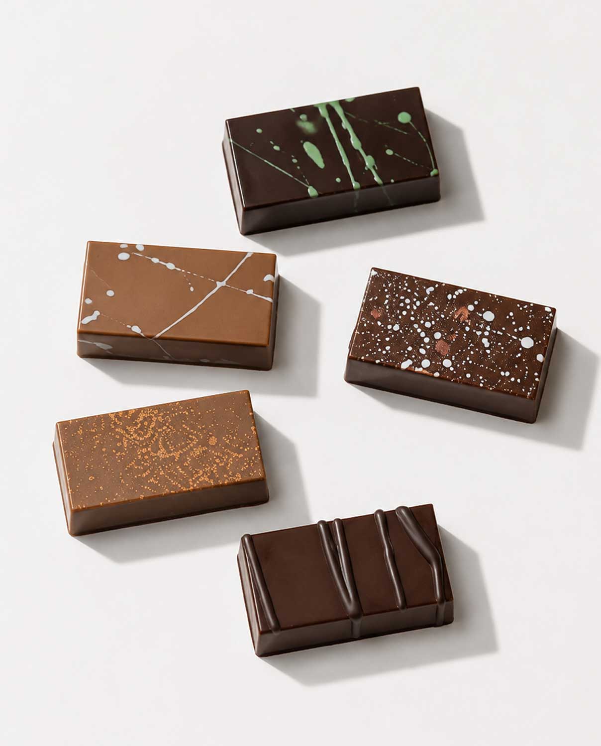 Bombons de xocolata decorats amb diferents acabats, exemple de tècniques de bomboneria i elaboració professional.